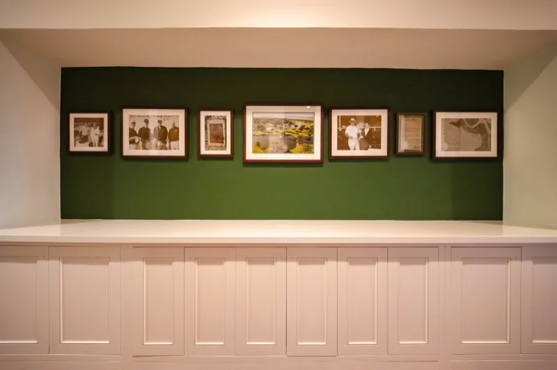 Card Sound Clubhouse gallery wall with framed photographs on a dark green accent wall